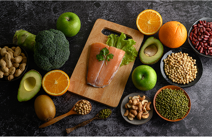 Whole foods, fruits, nuts and vegetables on a board